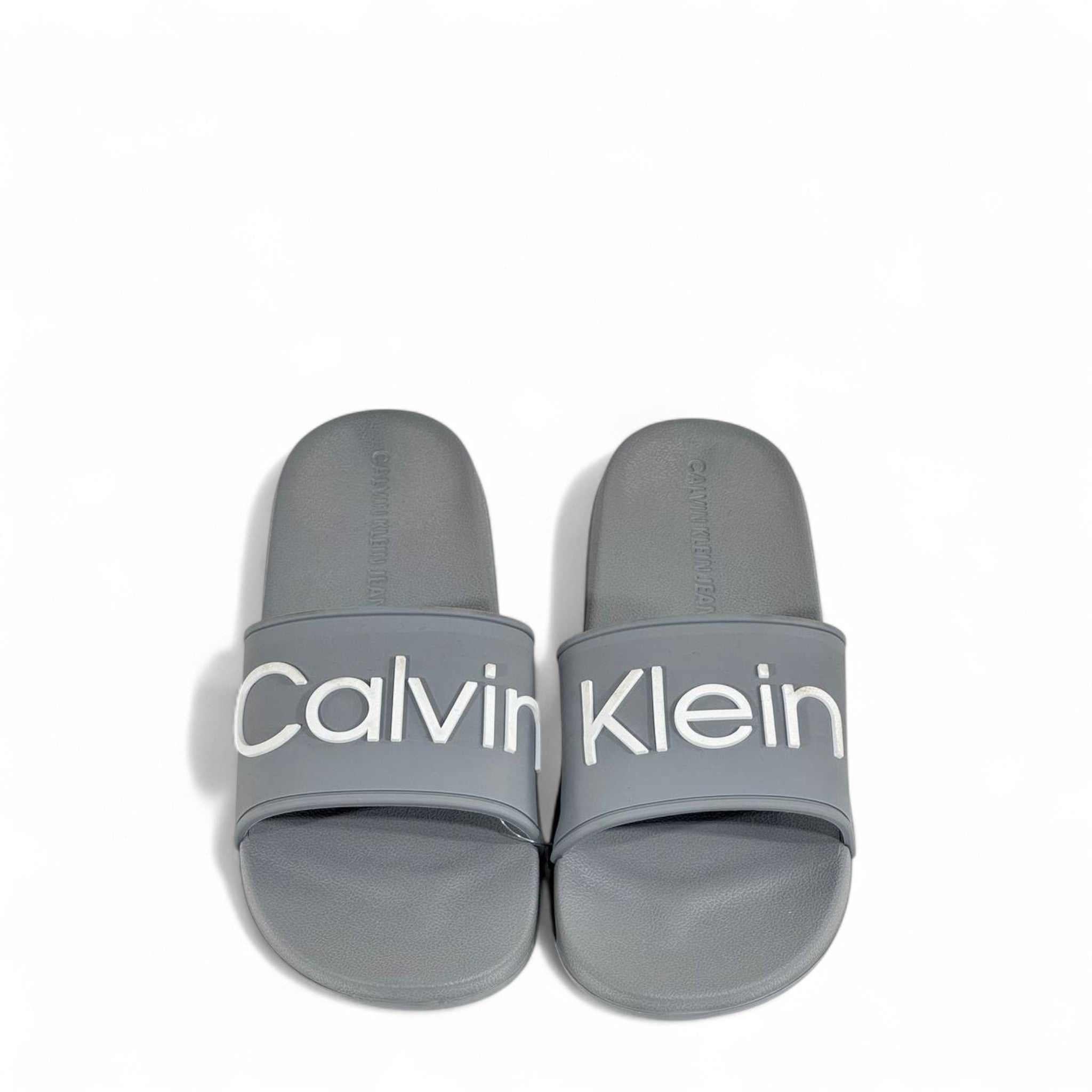 ⚪ Calvin Klein Grey Slides – Oversized White Logo Slippers