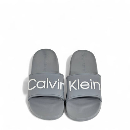 ⚪ Calvin Klein Grey Slides – Oversized White Logo Slippers
