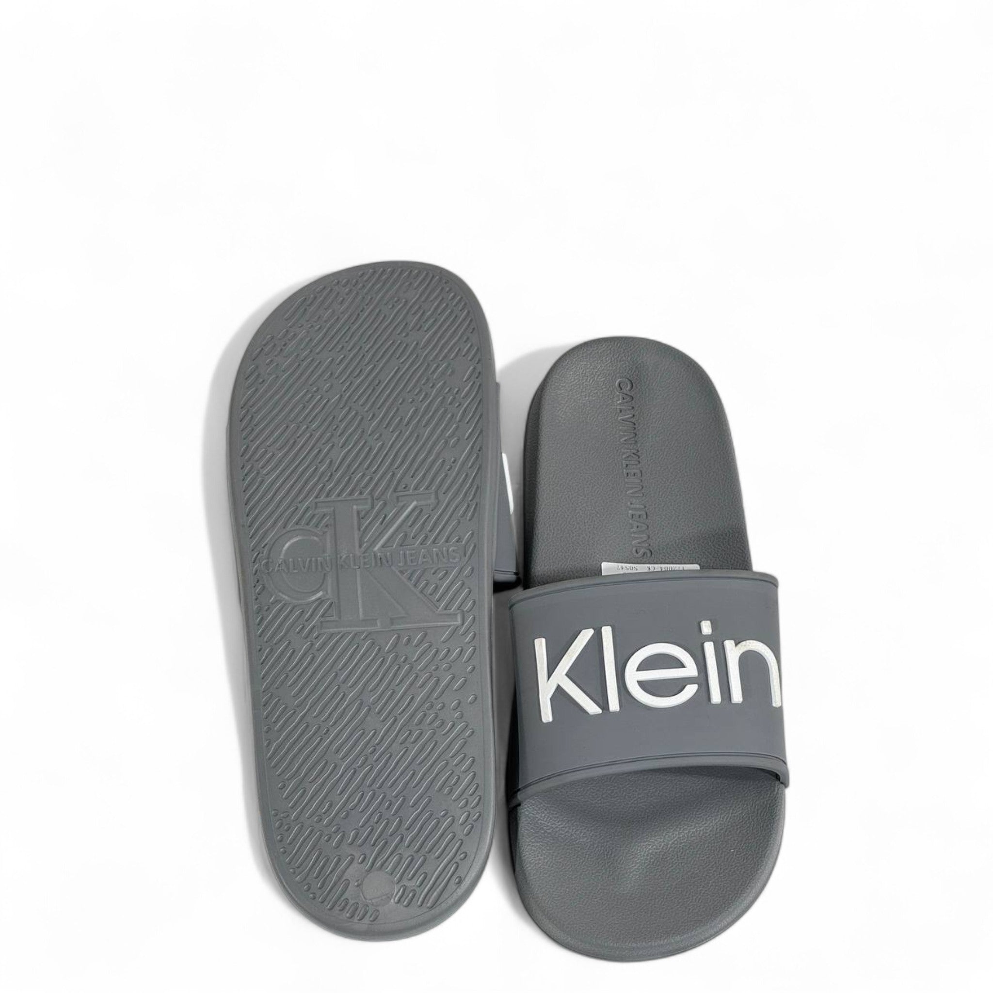 ⚪ Calvin Klein Grey Slides – Oversized White Logo Slippers
